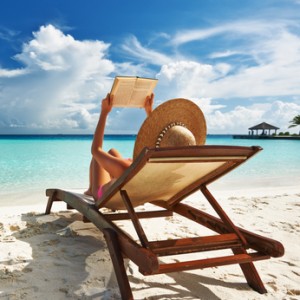 Young woman reading a book at beach